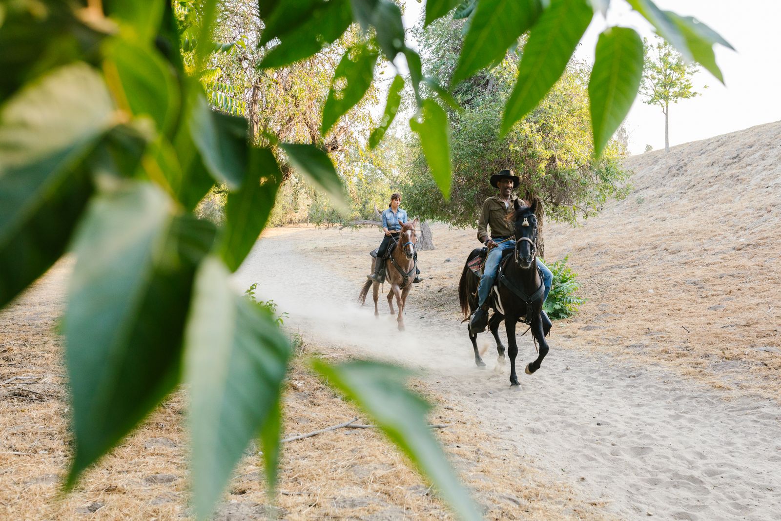 Deux cavaliers en balade a cheval sur un chemin, cheval de tete noir